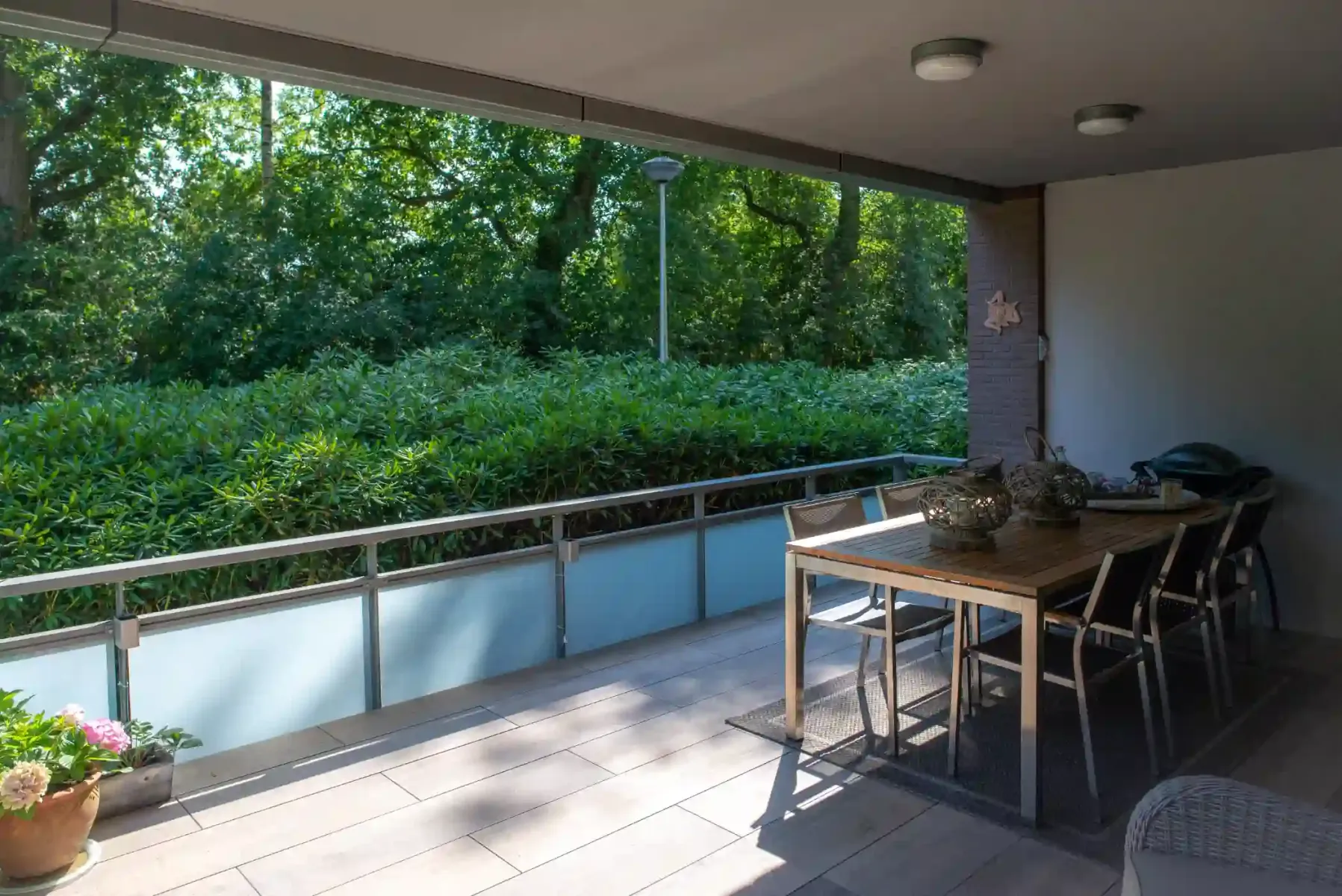 balkon met langwerpige tegels en een tafel met stoelen